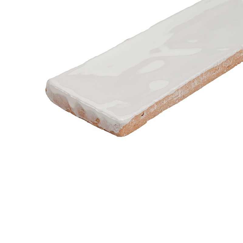 Azulejo rectangular esmaltado blanco, borde irregular y base de barro visible; colocado aislado sobre fondo blanco liso sin otros elementos.
