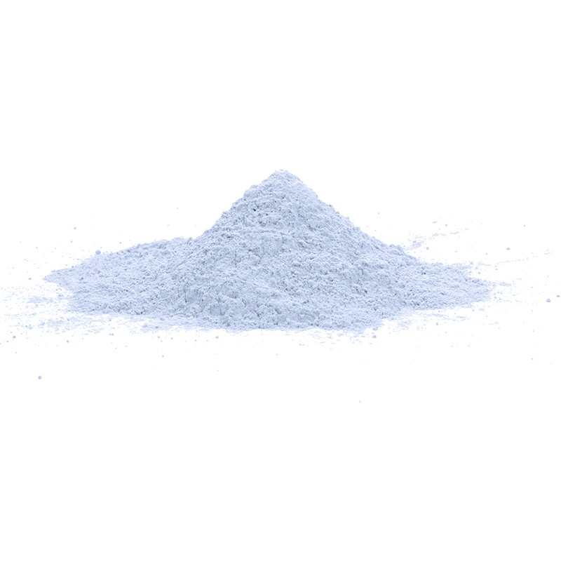 Una pequeña pila cónica de polvo fino de color azul claro se asienta sobre una superficie blanca y lisa, sobre un fondo blanco l