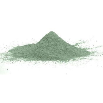 Um pequeno monte de pó fino e verde fica centralizado em uma superfície branca, espalhando-se ligeiramente para fora.