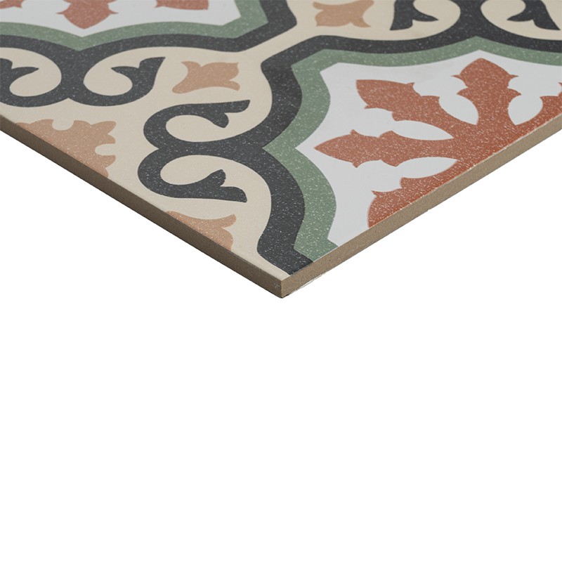 Carreau décoratif carré; motif floral et arabesques terracotta, vert, noir et beige sur fond blanc; coin exposant épaisseur brun clair et bord net.