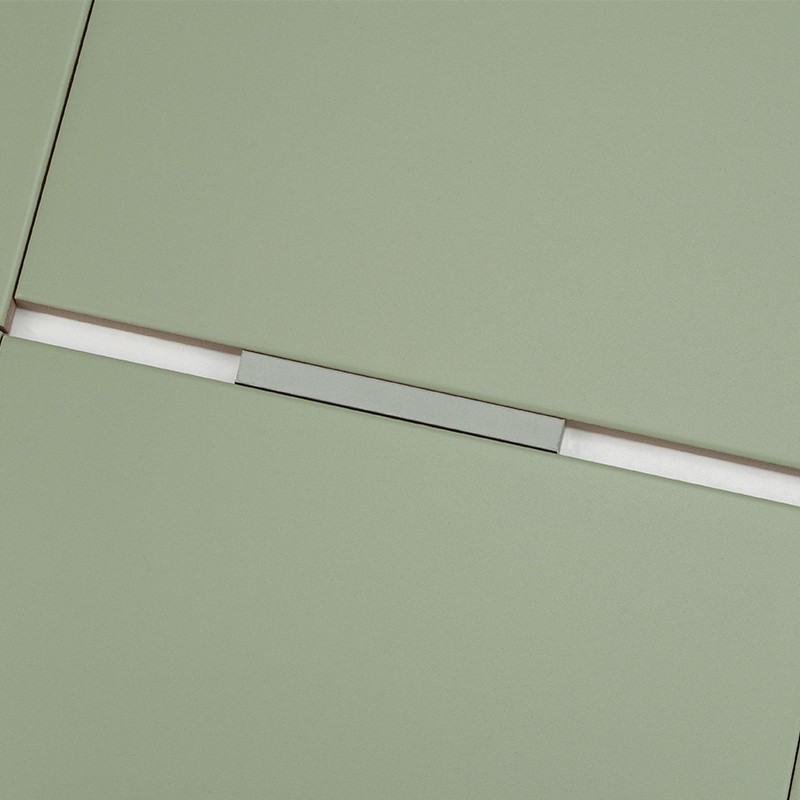 Rectangular sage green tile with white grout and narrow metal strip in the middle, aligned with other similar tiles forming a continuous surface.
