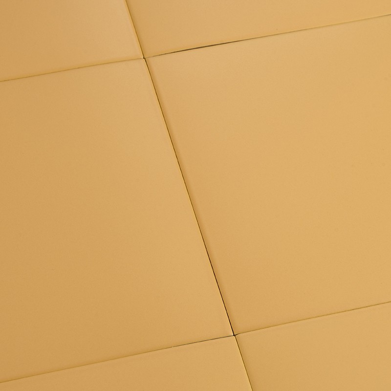 Beige quadratische Fliesen mit glatter, matter Oberfläche; sichtbare schmale Fugen, perspektivische Anordnung von vier Fliesen, gleichmäßige Farb- und Schattenverteilung.
