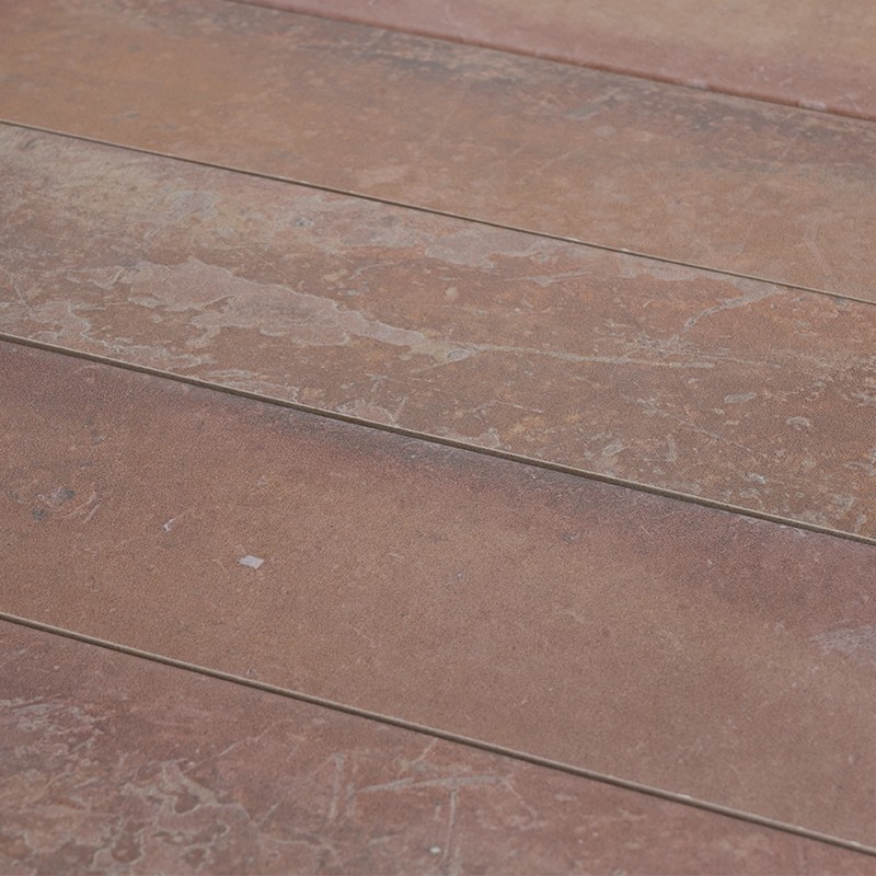 Rectangular reddish-brown tile with light veins and spots; arranged in horizontal plates with narrow joints, slightly worn surface and rough texture.