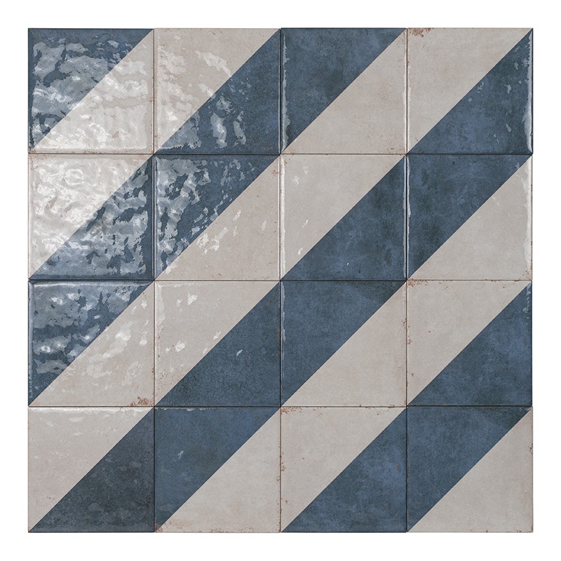 Carrelage carré à motif diagonal : carreaux bleus et blancs alternés formant bandes obliques, joints fins, surface légèrement brillante avec traces d'usure.