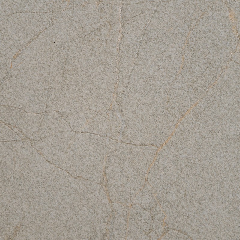 Azulejo cerámico grisáceo con textura arenosa y finas vetas marrón claro formando grietas; colocado en superficie plana, apariencia envejecida y uniforme.