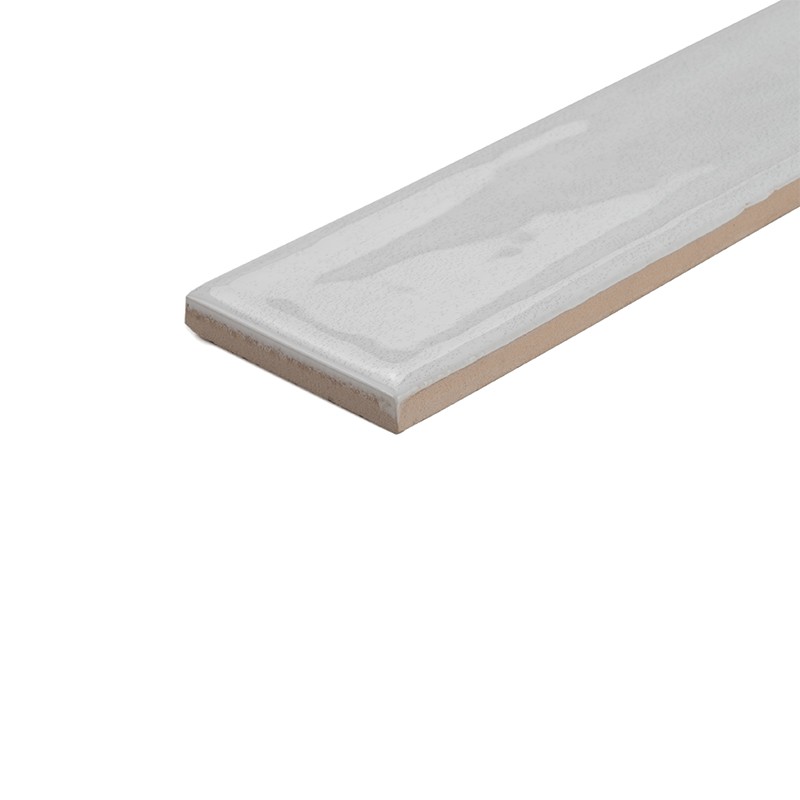 Carreau rectangulaire vernissé blanc-gris, bord beige apparent, posé en diagonale sur fond blanc neutre, montrant épaisseur et finition brillante.
