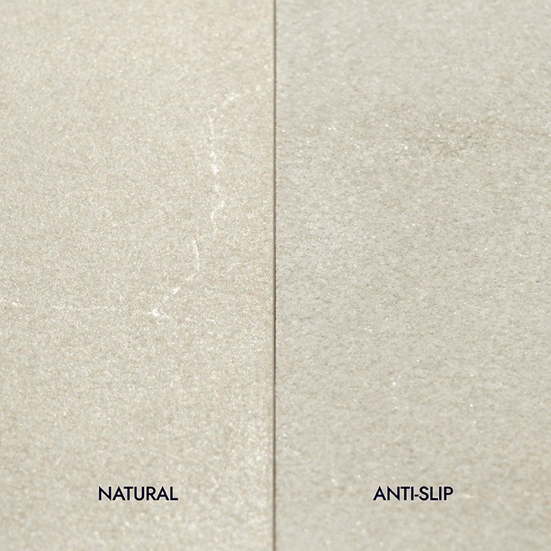 Light tile divided into two plates; left smooth with the text "NATURAL", right textured non-slip with the text "ANTI-SLIP", neutral beige tone.