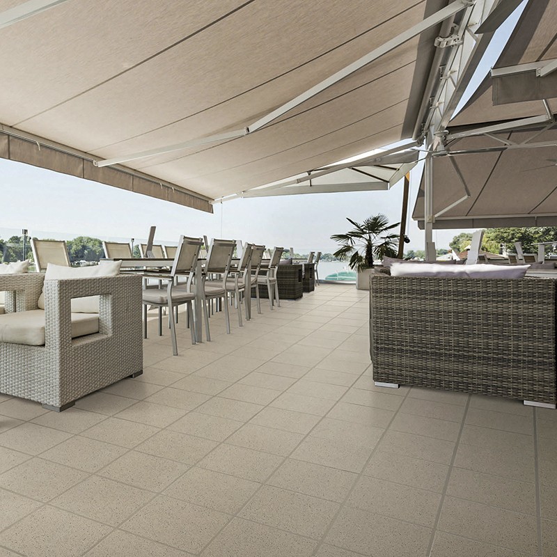 Azulejo beige cuadriculado; entorno: terraza amplia con muebles de mimbre, mesa y sillas, toldos retráctiles y piscina con palmera al fondo.