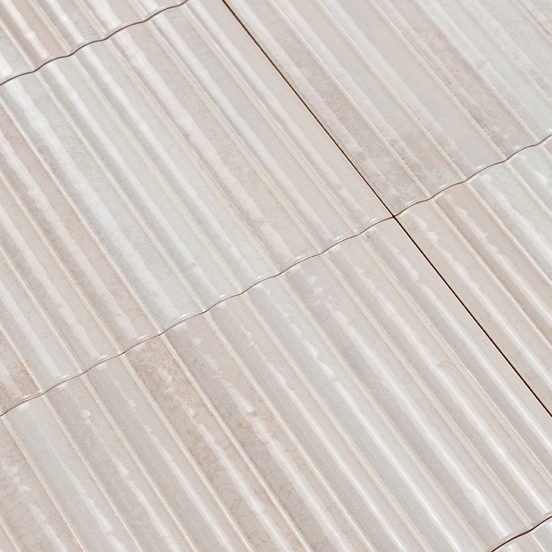 Gerillte beige Keramikfliesen in Reihen, sichtbare Fugen und leichte Oberflächenflecken; diagonal angeordneter, hellfarbener Bodenbelag.