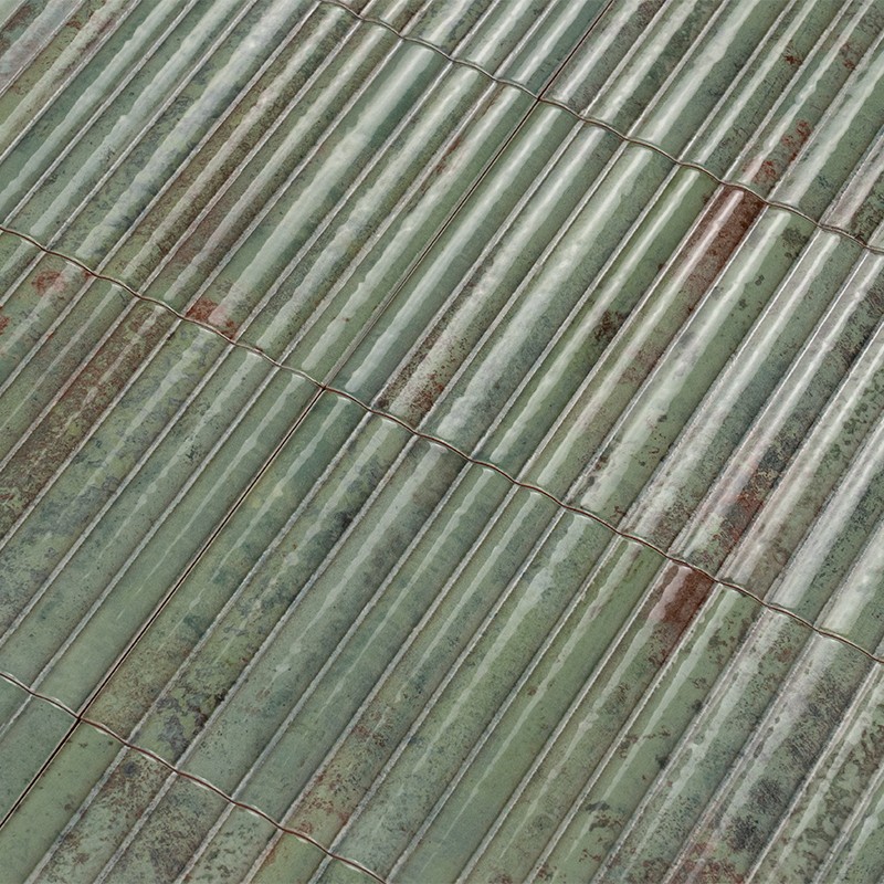 Telhas cerâmicas verdes em fileiras curvas; telhado envelhecido com manchas, musgo e sujeira acumulada entre os encaixes.