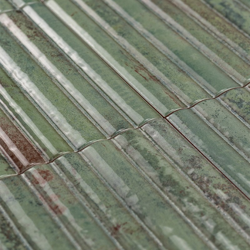 Geglazuurde groene rechthoekige tegels met verticale ribbels, barstjes en bruinige verweringsvlekken, in strak aaneengesloten rijen op een plat oppervlak.