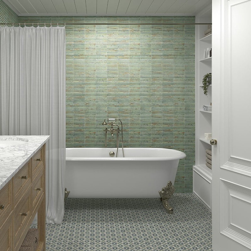 Grün-graue, schmale Mosaikfliesen an Wand; freistehende weiße Krallenbadewanne mit goldenen Füßen, Duschvorhang links, offenes Regal rechts, gemusterter Fliesenboden und Holzwaschtisch.