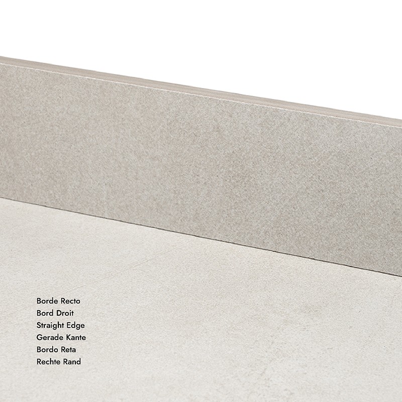 Carrelage beige clair, type plinthe verticale posée contre un sol carrelé similaire, angle bas visible, éclairage neutre.  Texte transcrit : Borde Recto Bord Droit Straight Edge Gerade Kante Bordo Retta Rechte Rand