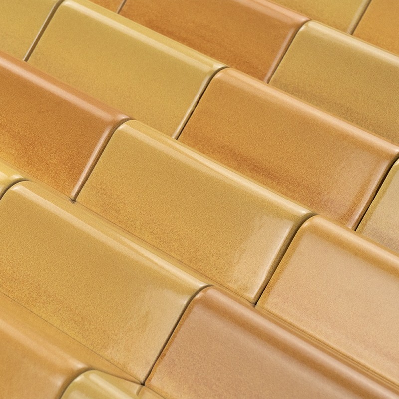 Carrelage rectangulaire émaillé aux tons jaunes et ocre, posé en quinconce sur surface plane, fini brillant montrant de légères variations de teinte.