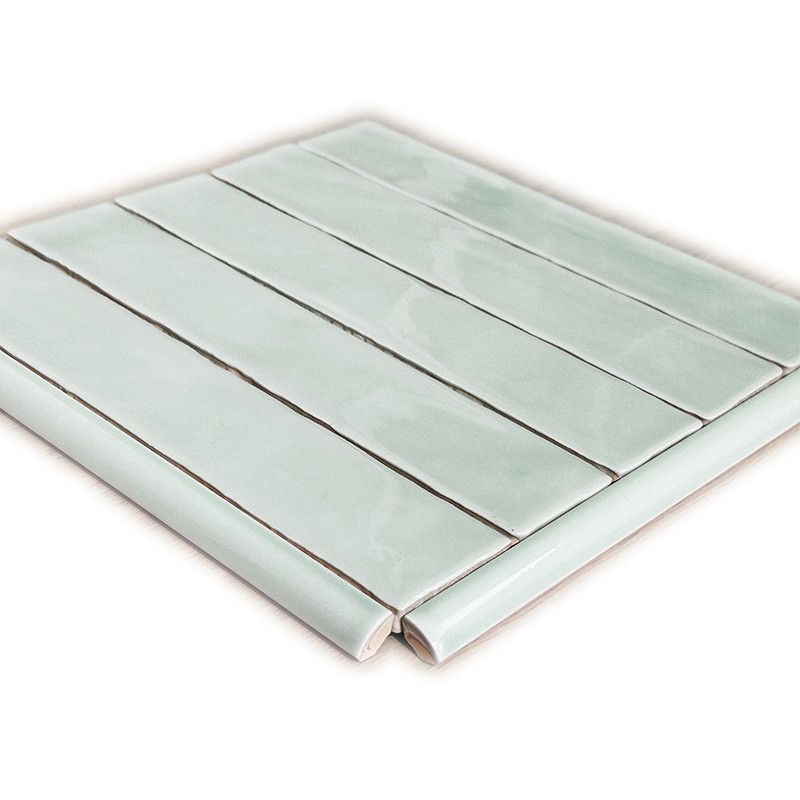 Azulejo cerâmico retangular verde‑água brilhante, disposto em fileiras paralelas com juntas escuras; placa de amostra apoiada sobre fundo branco.