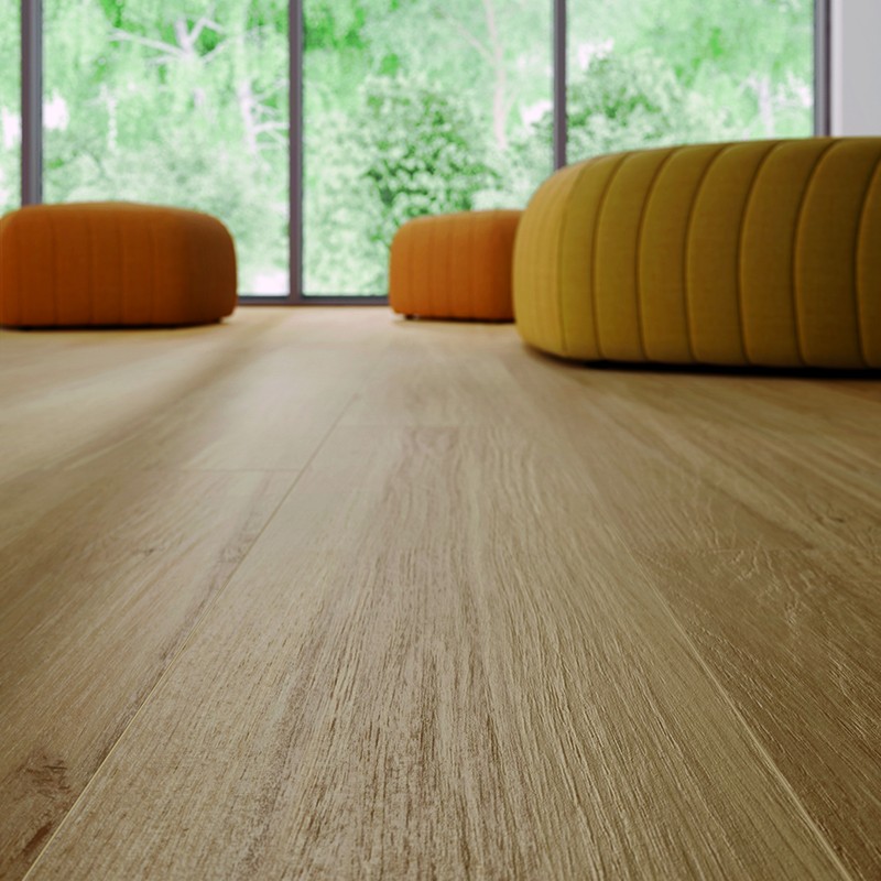 Lichte houtlook tegelvloer op de voorgrond; achteraan drie lage, ronde poefs in geel/oranje voor grote glazen ramen met groen tuinzicht.