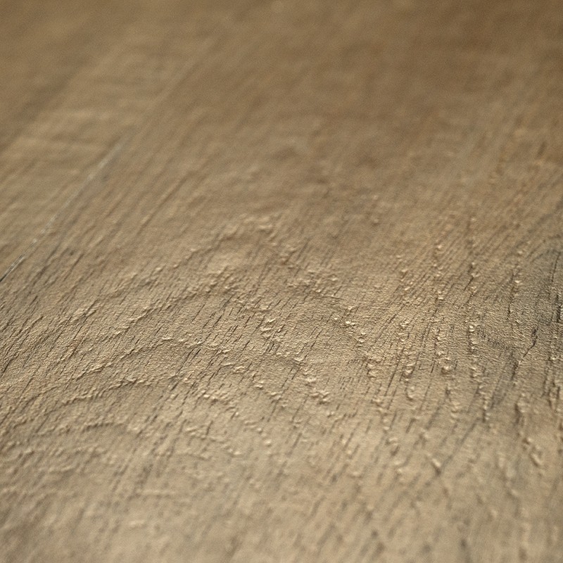 Azulejo bege com textura rugosa imitando madeira; close-up de veios e sulcos, brilho suave, possivelmente parte de piso interno sob iluminação lateral.