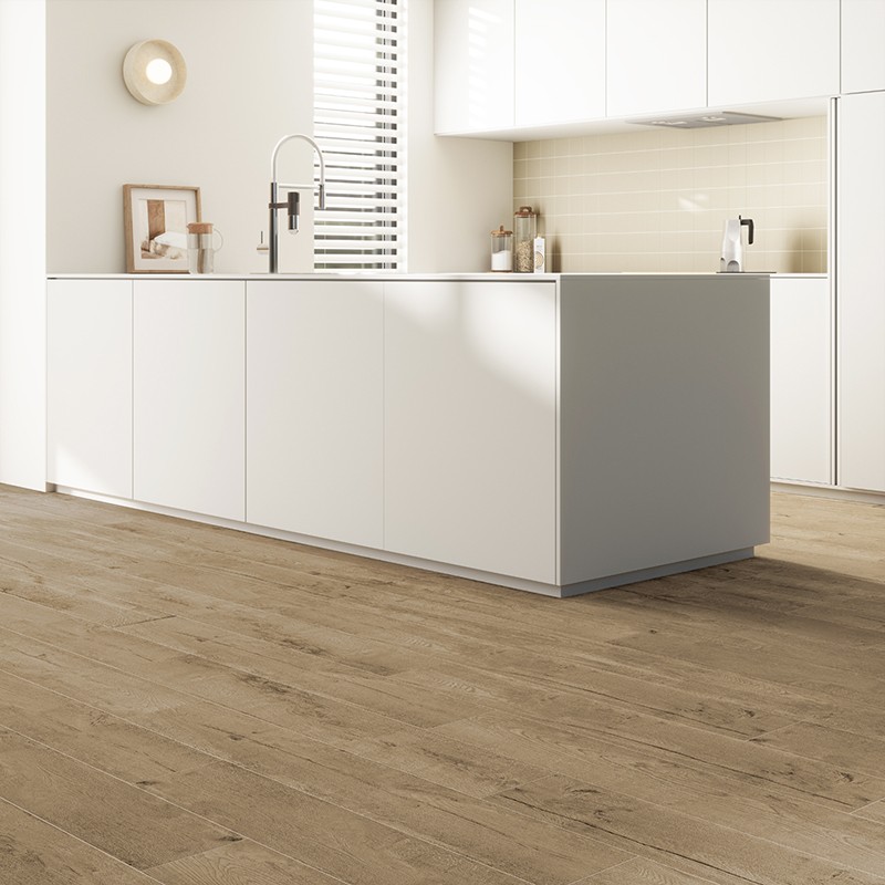 Suelo de lamas efecto madera color roble; contexto: cocina minimalista blanca con isla central, fregadero y grifo cromado, zócalo y salpicadero en tonos claros.