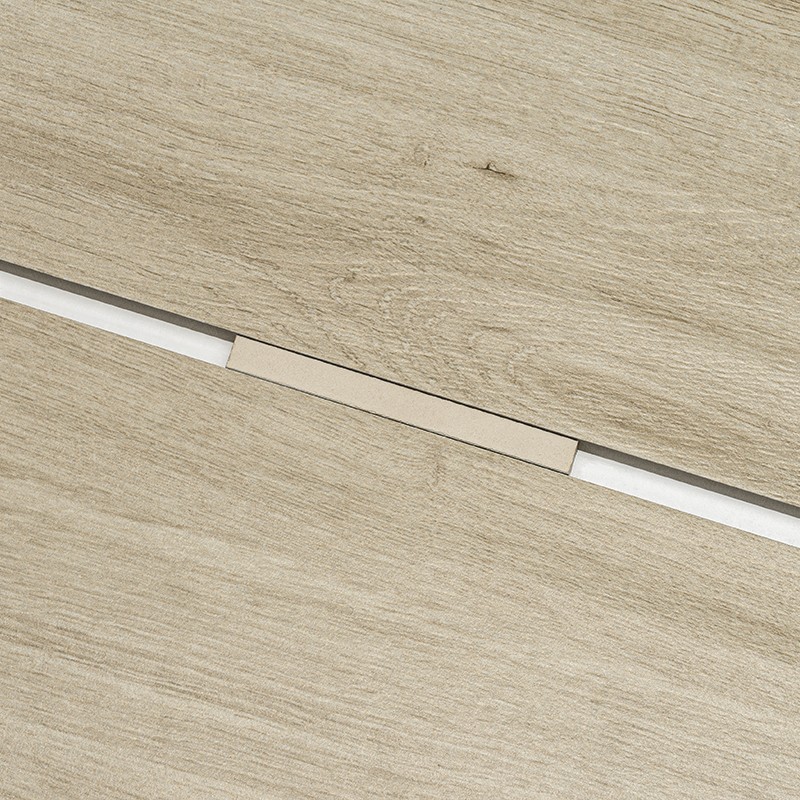 Carrelage imitation bois: deux lames claires séparées par un joint blanc, reliées par un petit profilé rectangulaire beige.