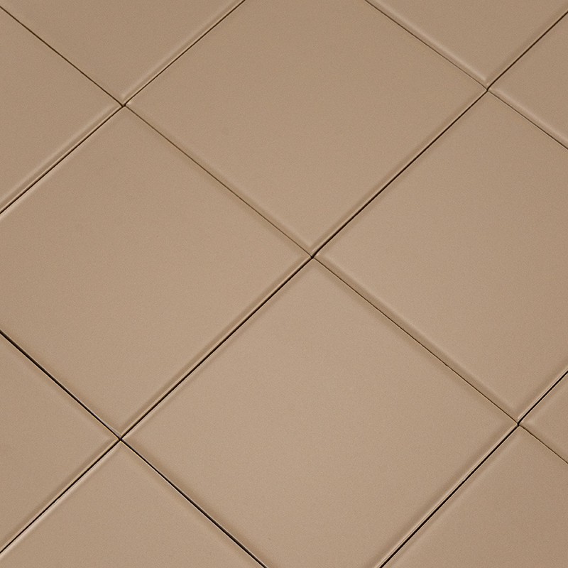 Plain beige square tile in the foreground; several identical tiles arranged in a grid with thin joints, matte surface and slight relief on the bevels.