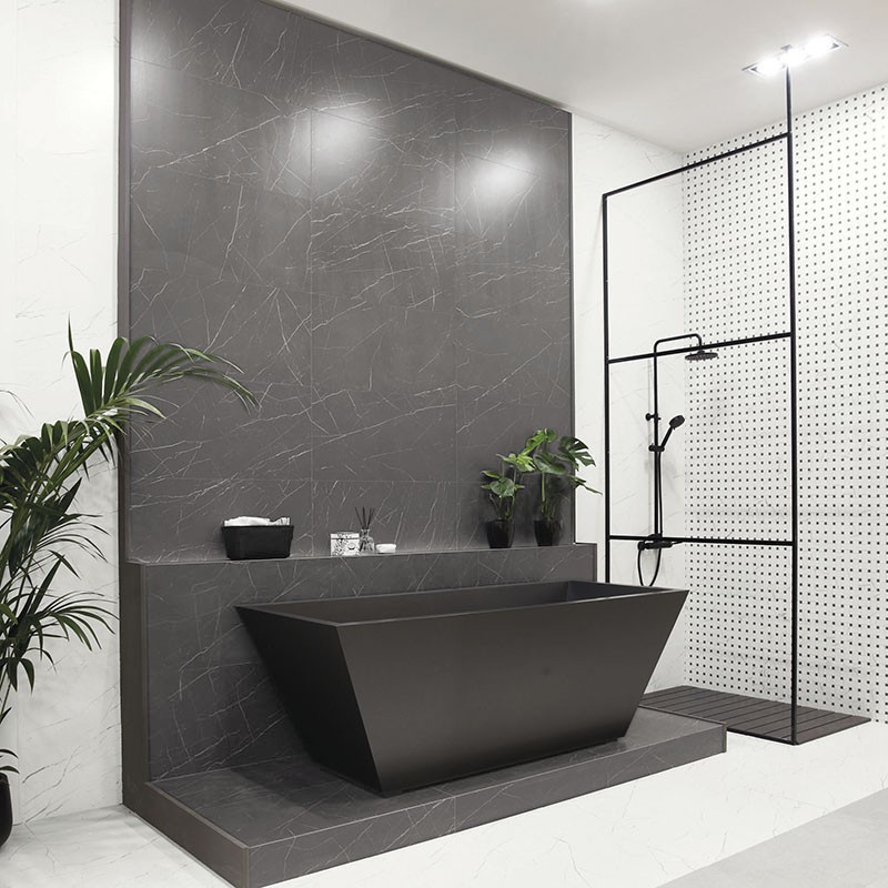 Uma elegante e moderna banheira de cor cinza escuro repousa contra uma parede decorativa combinando. O ambiente ao redor apresenta Uma elegante e moderna banheira de cor cinza escuro repousa contra uma parede decorativa combinando. O ambiente ao redor apresenta