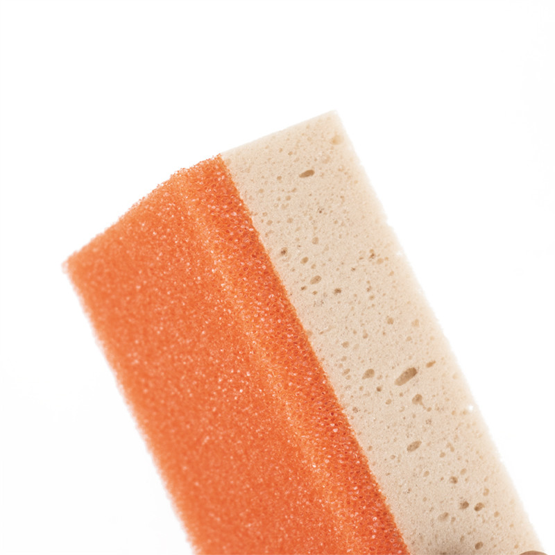 Esponja de duas camadas. lado superior laranja e lado inferior bege. em pé sobre um fundo liso e branco, sugerindo versatilidade