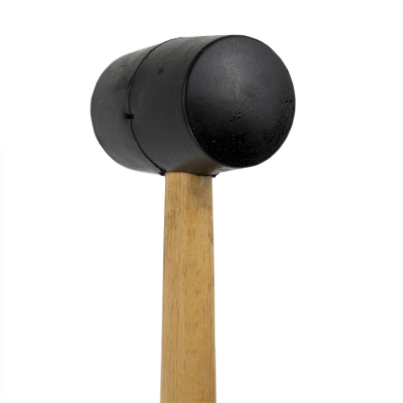 Auf weißem Hintergrund ruht ein Gummihammer mit schwarzem Kopf. Es hat einen Holzgriff mit einem sichtbaren Produktetikett: „NF 