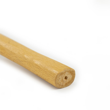 Auf einem weißen Hintergrund ruht ein Holzstab mit glatter zylindrischer Form und einem kleinen Loch am sichtbaren Ende. Auf einem weißen Hintergrund ruht ein Holzstab mit glatter zylindrischer Form und einem kleinen Loch am sichtbaren Ende.