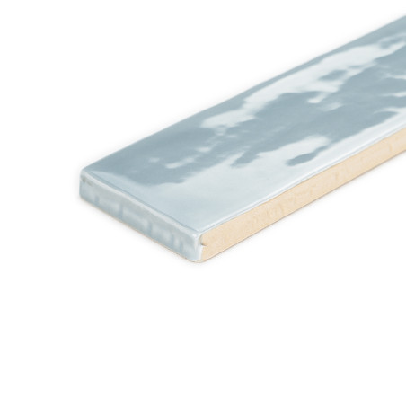 Rechteckige Fliese mit glänzender, hellblauer Oberfläche und dezenter Wellenstruktur vor einem schlichten weißen Hintergrund. Rechteckige Fliese mit glänzender, hellblauer Oberfläche und dezenter Wellenstruktur vor einem schlichten weißen Hintergrund.