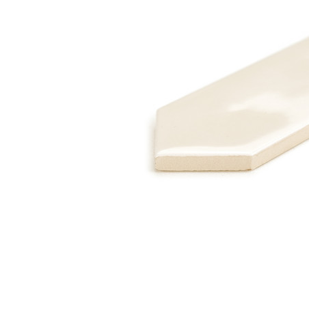 Een glanzende, gebroken witte tegel met spitse rand rust op een wit oppervlak en reflecteert het licht op subtiele wijze in een 