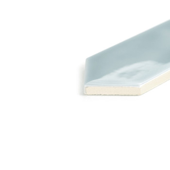 Um ladrilho azul claro fino e brilhante com uma borda chanfrada repousa sobre uma superfície branca, exibindo seu único canto em