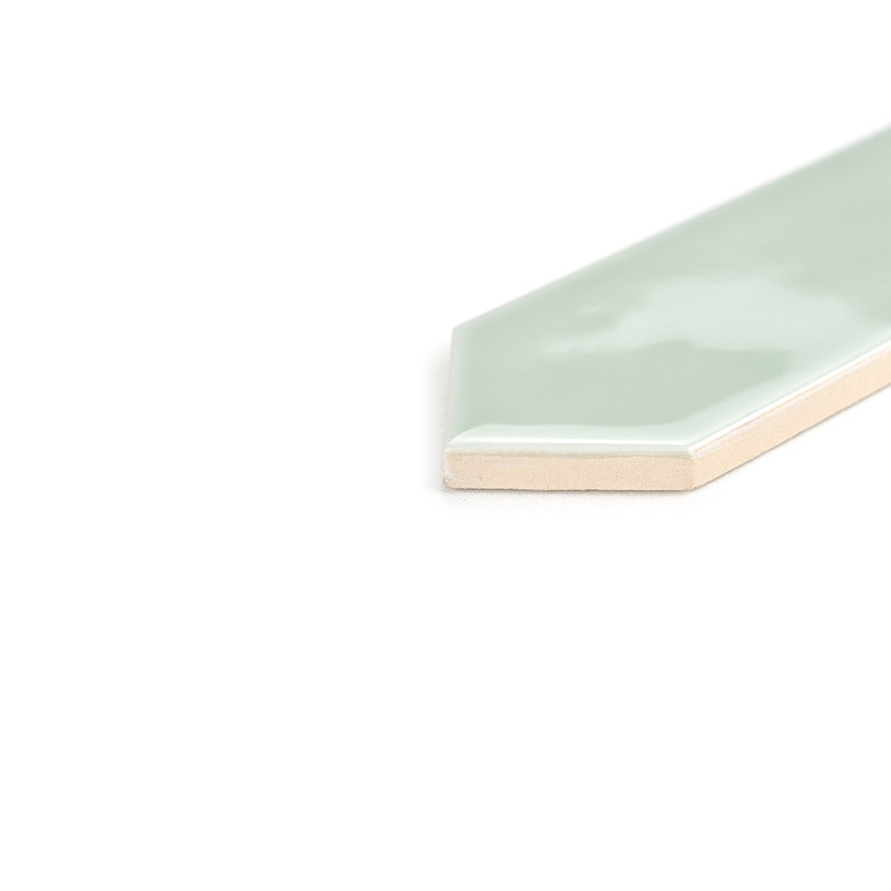 Un azulejo hexagonal brillante de color verde menta con un borde biselado se encuentra en ángulo sobre un fondo blanco liso, ref