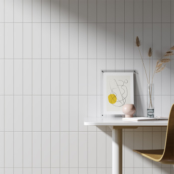 Uma parede de azulejos brancos oferece um cenário elegante para um espaço de trabalho minimalista, com um desenho abstrato emold
