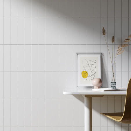 Un mur carrelé blanc constitue une toile de fond élégante pour un espace de travail minimaliste, avec un dessin abstrait encadré