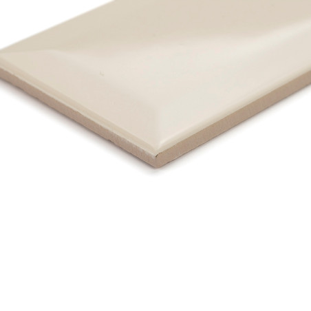 Eine rechteckige, beige Keramikfliese liegt flach und weist eine glatte, glänzende Oberfläche und abgeschrägte Kanten auf, geeig