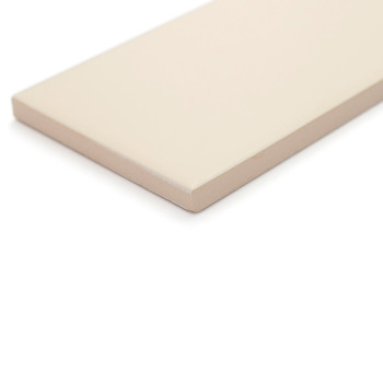 A rectangular, smooth, beige tile rests on a white surface, displaying its flat, clean surface and sharp, angled edges.