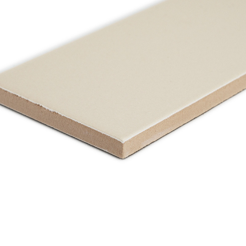 Eine beige rechteckige Keramikfliese liegt flach auf einer weißen Oberfläche und zeigt in einer Studioumgebung eine glatte Obers