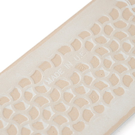 Eine beige, rechteckige Fliese zeigt ein sich wiederholendes geometrisches Muster. „MADE IN U.E.“ ist mittig eingeprägt, was auf Eine beige, rechteckige Fliese zeigt ein sich wiederholendes geometrisches Muster. „MADE IN U.E.“ ist mittig eingeprägt, was auf