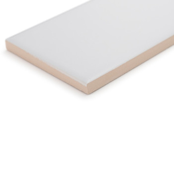 Eine rechteckige Keramikfliese liegt auf einer weißen Oberfläche und zeigt eine glatte, glänzende weiße Oberseite und einen matt