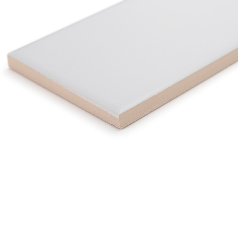 Un carreau de céramique rectangulaire repose sur une surface blanche, mettant en valeur un dessus blanc lisse et brillant et un 