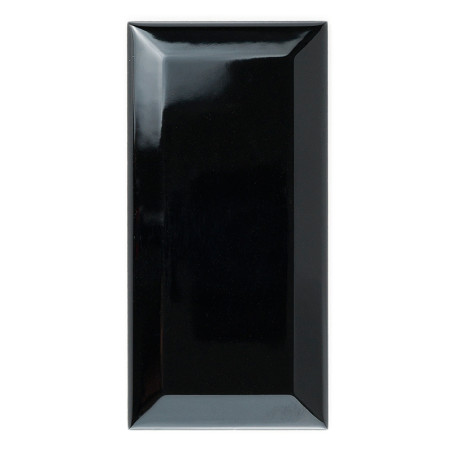Eine glänzende, rechteckige schwarze Keramikfliese steht aufrecht vor einem weißen Hintergrund und reflektiert das Licht auf ihr