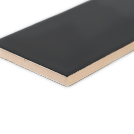 Un azulejo cerámico rectangular, con una superficie negra lisa y una parte inferior beige, descansa sobre un fondo blanco liso. Un azulejo cerámico rectangular, con una superficie negra lisa y una parte inferior beige, descansa sobre un fondo blanco liso.