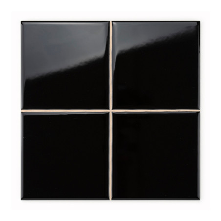 Quatre carreaux de céramique noirs brillants forment un carré, avec des lignes de coulis épurées qui se croisent, créant une sur