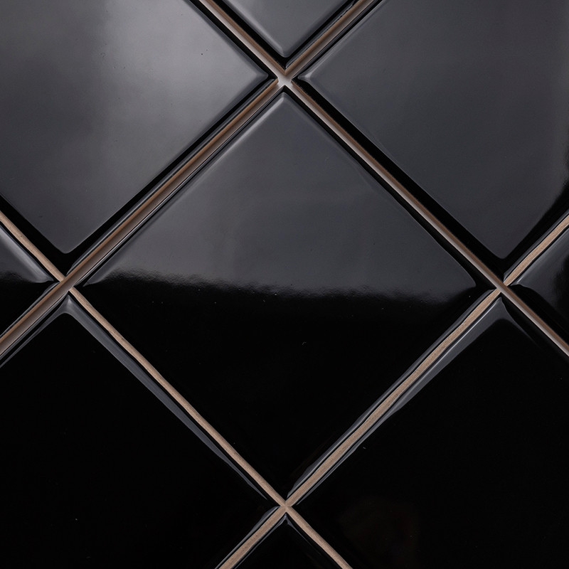 Los azulejos negros brillantes con forma de diamante están dispuestos en un patrón limpio y repetitivo, creando una superficie e
