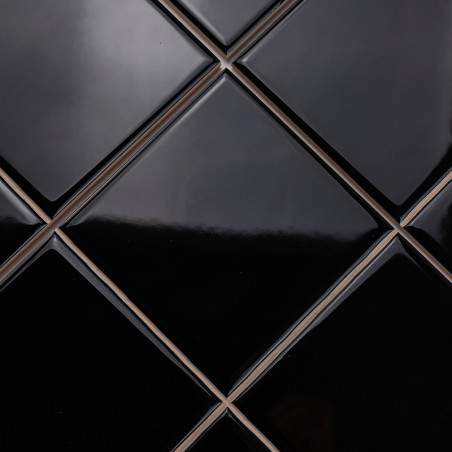 Shiny, black, diamond-shaped tiles are arranged in a neat, repeating pattern, creating a sleek and modern surface.