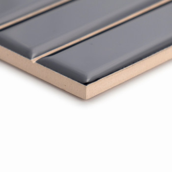 A rectangular tile with raised, glossy dark gray strips sits atop a beige surface, highlighting its sleek, modern design.