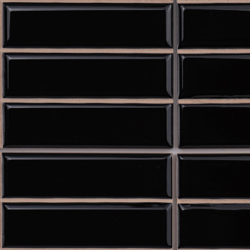 Les carreaux rectangulaires noirs sont disposés en grille, séparés par des lignes de coulis beiges, créant une surface élégante 