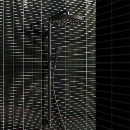 Une pomme de douche noire mate est montée sur une barre verticale élégante avec une buse à main, posée sur des carreaux horizont