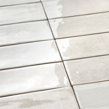 Rechteckige Keramikfliesen sind in einem Raster angeordnet, reflektieren das Licht, erzeugen eine glänzende Oberfläche und stehe