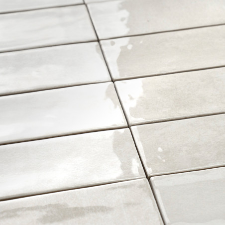 Rechteckige Keramikfliesen sind in einem Raster angeordnet, reflektieren das Licht, erzeugen eine glänzende Oberfläche und stehe